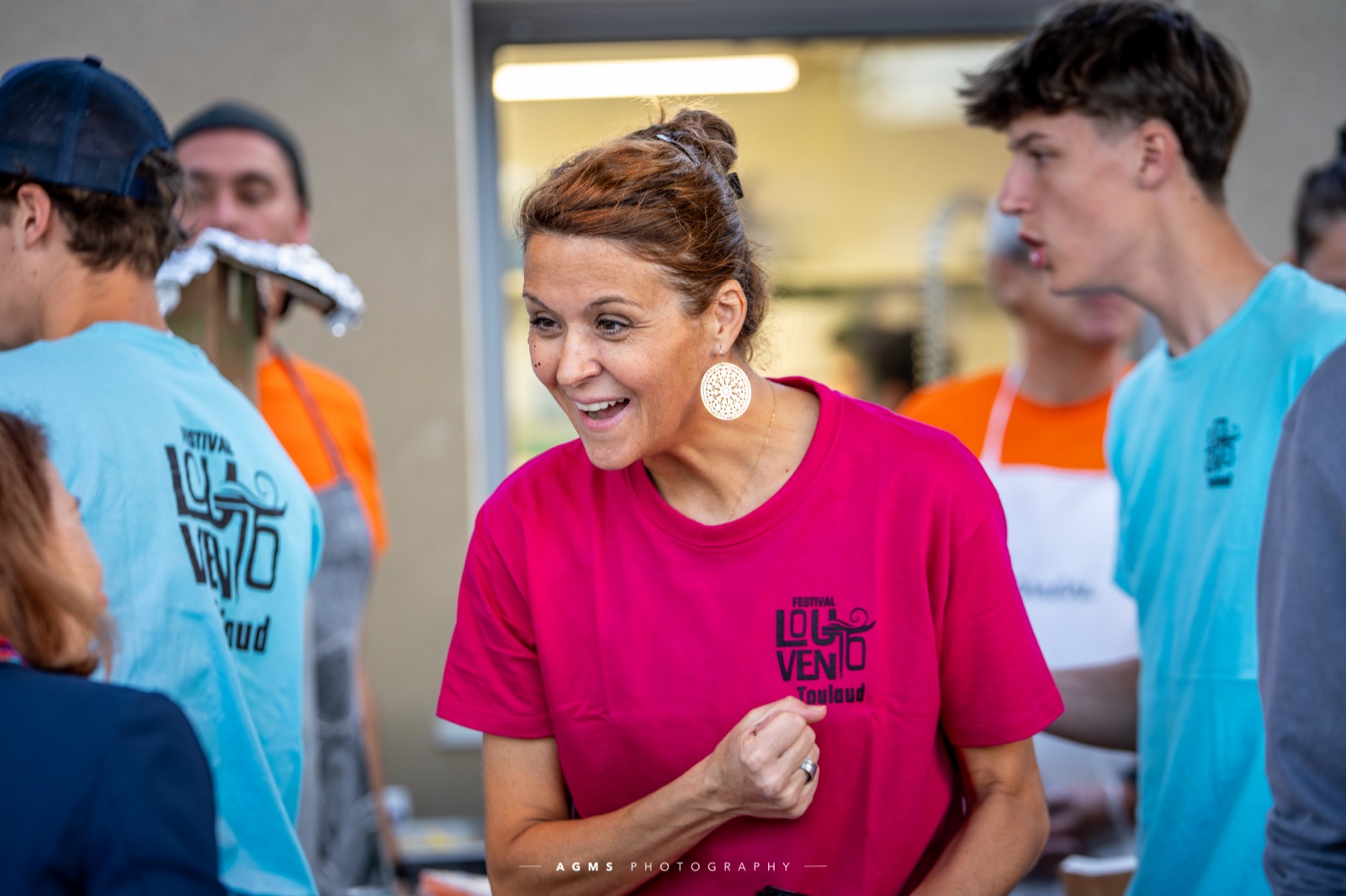 Une bénévole en t-shirt Lou Vento en plein service